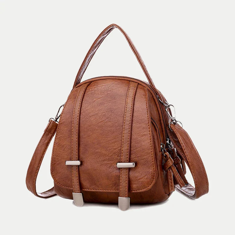 Zaino in pelle marrone, design elegante e compatto, con manico superiore e tracolla regolabile. Ideale per moda donna e accessori di tendenza.