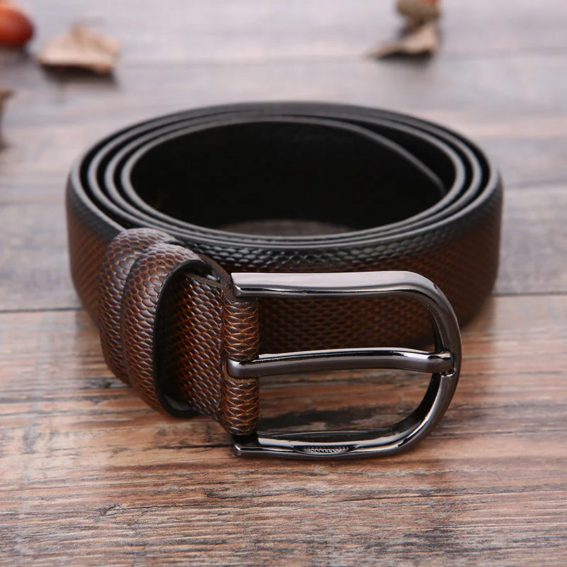 Cintura in pelle marrone scuro con fibbia in metallo lucido su sfondo in legno. Accessorio moda uomo elegante e versatile.