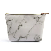 Astuccio cosmetico in ecopelle effetto marmo bianco con cerniera dorata, elegante e pratico per trucchi e accessori da viaggio.
