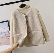 Gilet in pile beige con bottoni, appeso su gruccia. Design casual, ideale per l'inverno. Moda donna, abbigliamento caldo e confortevole.