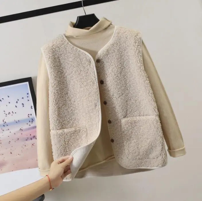 Gilet in pile beige con bottoni, appeso su gruccia. Design casual, ideale per l'inverno. Moda donna, abbigliamento caldo e confortevole.