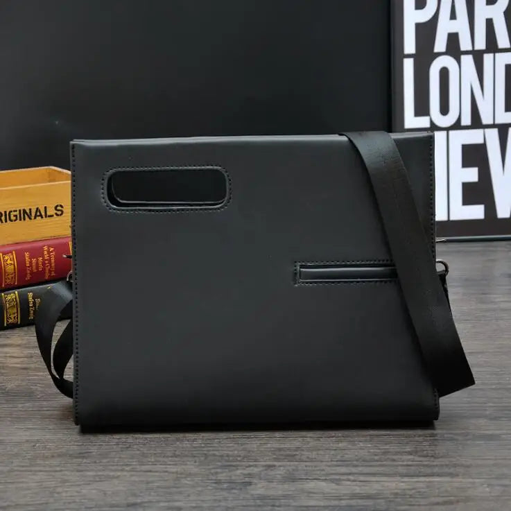 Elegante borsa a tracolla nera in pelle, design minimalista, con manico integrato e tasca frontale, su sfondo moderno. Accessorio moda uomo.