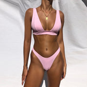 Modello indossa bikini rosa a vita alta, design minimalista, su sfondo bianco. Costume da bagno estivo, moda mare donna, tendenza 2023.