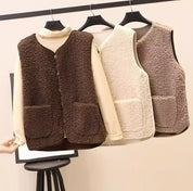 Gilet in pile morbido appeso su grucce, colori marrone e beige, con tasche frontali. Moda autunno inverno, abbigliamento casual caldo e confortevole.