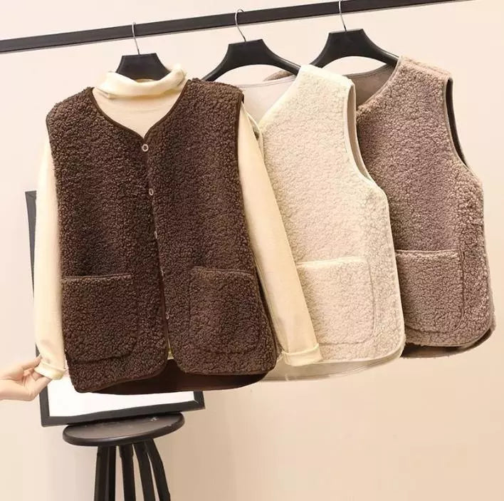 Gilet in pile morbido appeso su grucce, colori marrone e beige, con tasche frontali. Moda autunno inverno, abbigliamento casual caldo e confortevole.