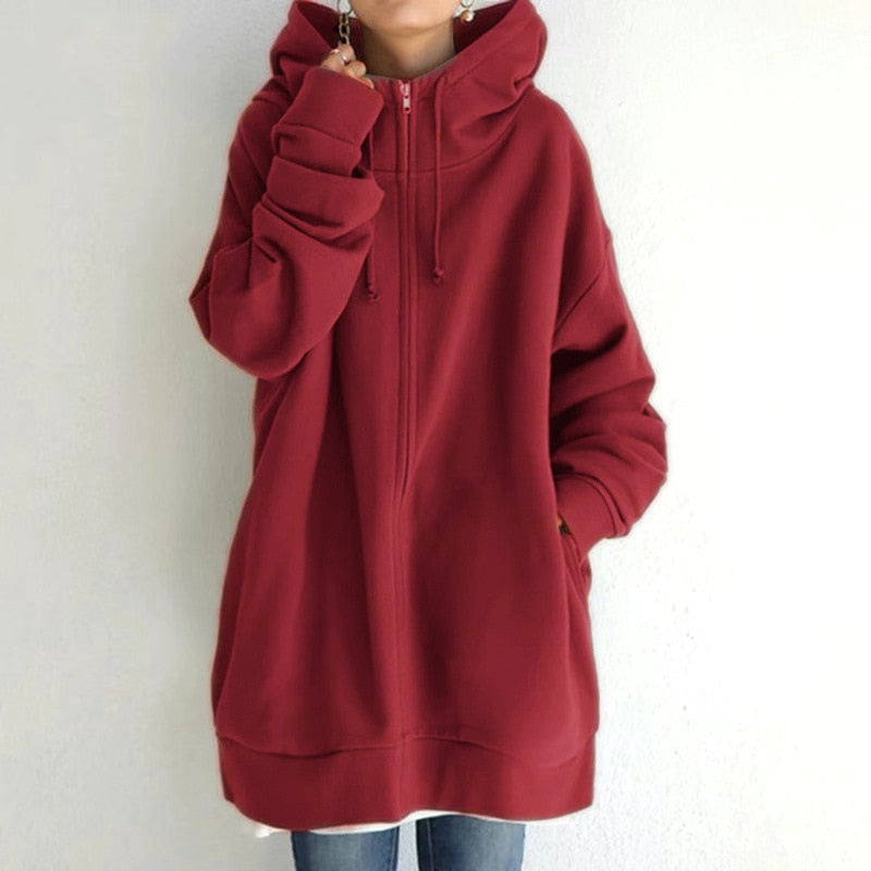 Felpa oversize rossa con cappuccio, zip frontale e tasche laterali, indossata da una persona. Abbigliamento casual autunnale, moda streetwear.