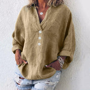 Camicia donna in lino beige con bottoni bianchi, maniche lunghe arrotolate, abbinata a jeans strappati. Stile casual, moda estiva.