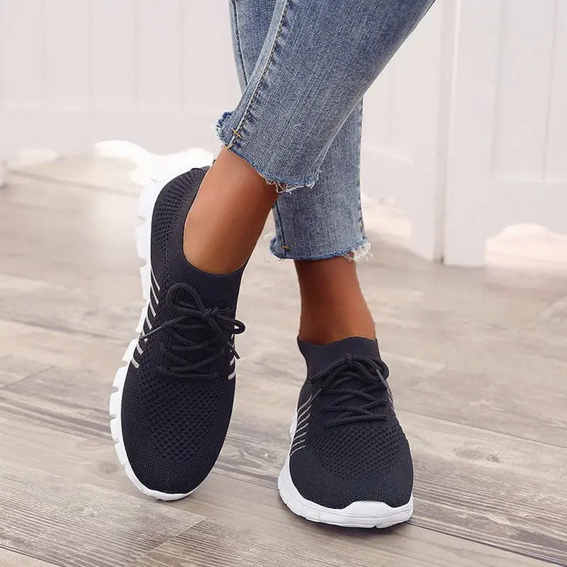 Scarpe da ginnastica nere da donna, design traspirante, suola bianca antiscivolo, abbinate a jeans. Ideali per sport e tempo libero.