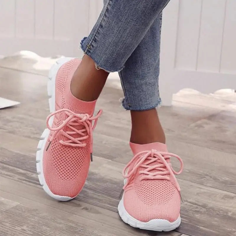 Scarpe da ginnastica rosa donna, design traspirante, suola bianca antiscivolo, indossate con jeans. Ideali per sport e tempo libero.