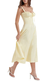 Abito midi giallo chiaro con spalline sottili, scollo a cuore e gonna svasata. Perfetto per eventi estivi eleganti. Scarpe con tacco incluse.