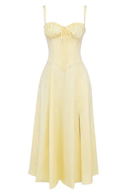 Abito giallo chiaro con spalline sottili, corpetto arricciato e gonna a pieghe. Elegante vestito estivo, moda donna, abbigliamento casual chic.