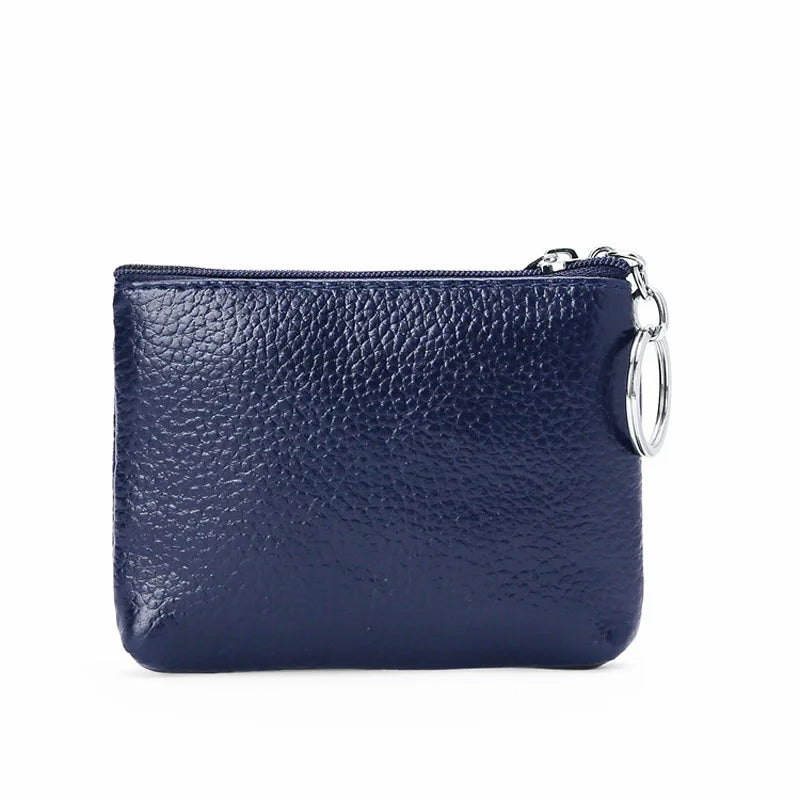 Portamonete in pelle blu scuro con chiusura a zip e anello metallico. Design elegante e compatto, ideale per accessori moda e organizzazione.