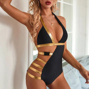 Costume intero nero e oro da donna, design asimmetrico con dettagli metallici, ideale per moda mare estiva. Elegante e moderno.