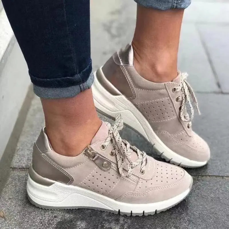 Scarpe da ginnastica beige da donna, design moderno con suola spessa bianca, lacci e dettagli traforati. Ideali per look casual e sportivi.