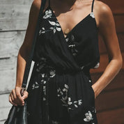 Abito nero estivo con stampa floreale bianca, scollo a V e spalline sottili. Perfetto per moda donna, look casual ed elegante.