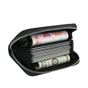 Portafoglio nero aperto con cerniera, contenente banconote di dollari e yuan. Design compatto, ideale per viaggi e uso quotidiano.