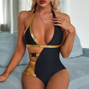Costume intero donna nero e oro, design asimmetrico con dettagli cut-out, scollatura profonda, ideale per moda mare estate.