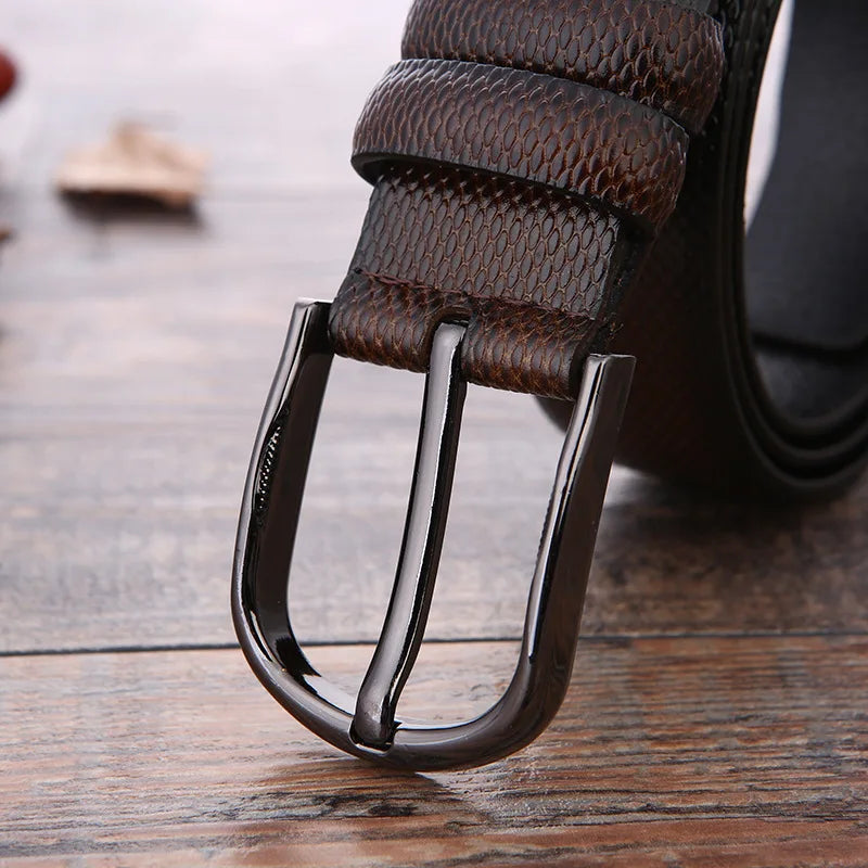 Cintura in pelle marrone con fibbia metallica lucida su sfondo in legno. Accessorio moda uomo elegante, alta qualità, stile classico.