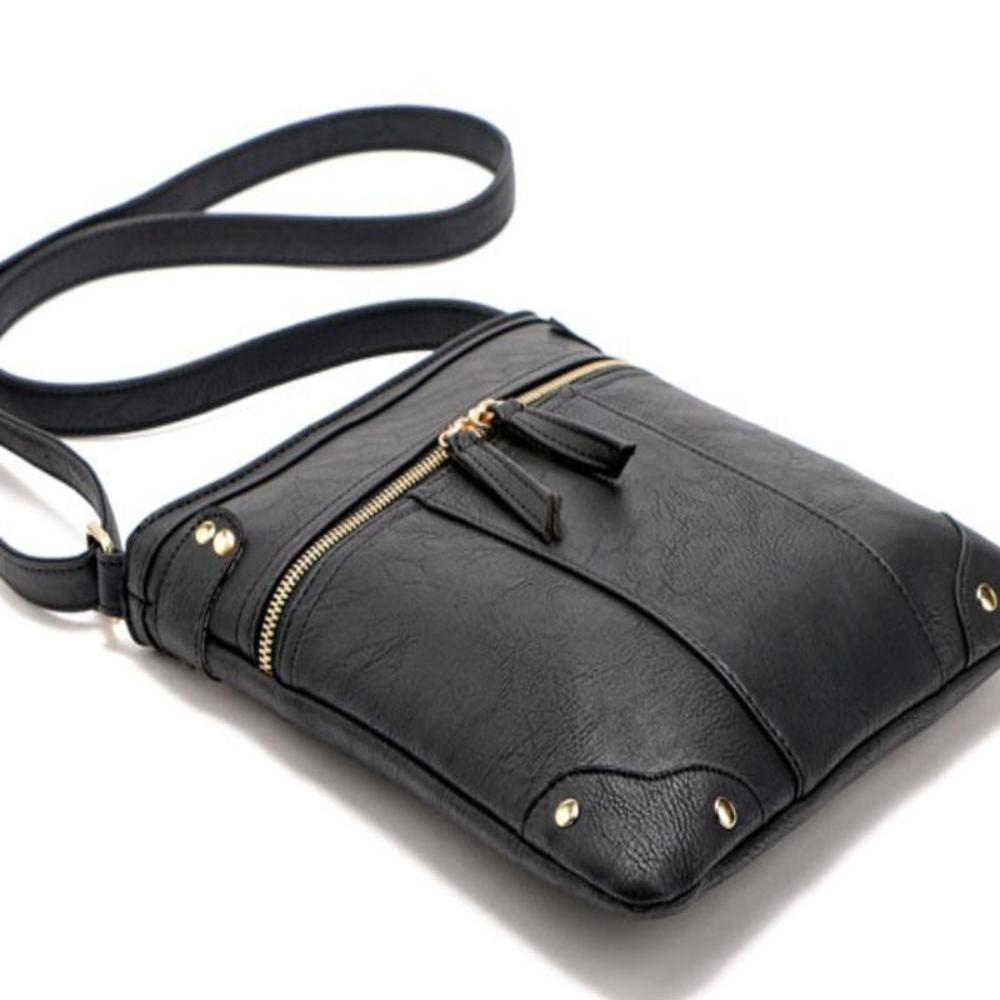 Borsa a tracolla in pelle nera con cerniera dorata e dettagli borchiati, design elegante e moderno, ideale per moda femminile e accessori.