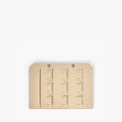 Tappetino organizer in feltro beige per borse, con scomparti multipli e due occhielli metallici, ideale per accessori e oggetti personali.