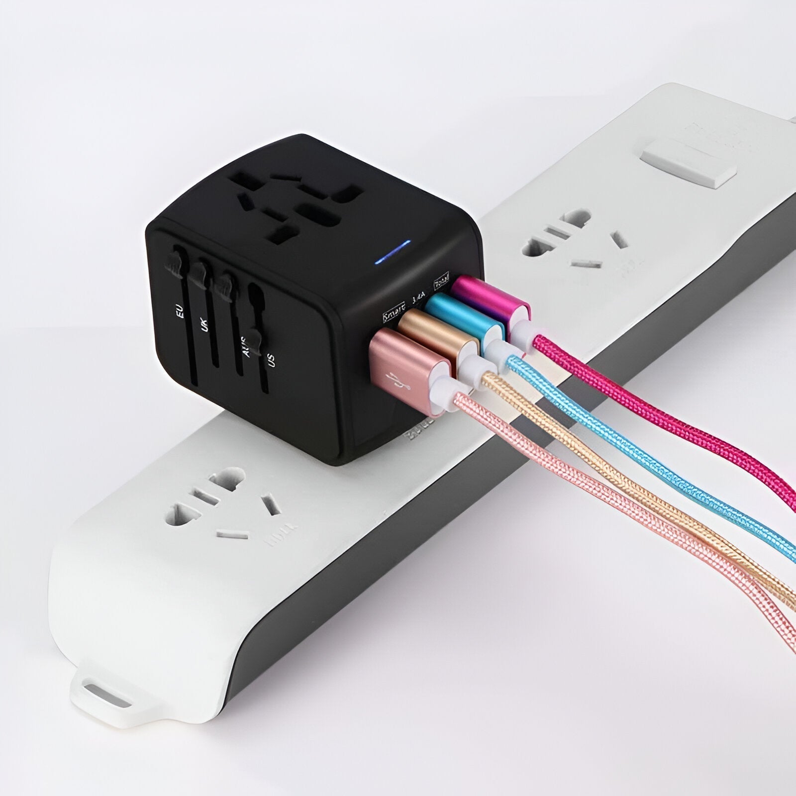 Adattatore universale da viaggio nero con porte USB multiple, collegato a una presa multipla bianca. Cavi colorati connessi. Accessorio elettronico versatile.