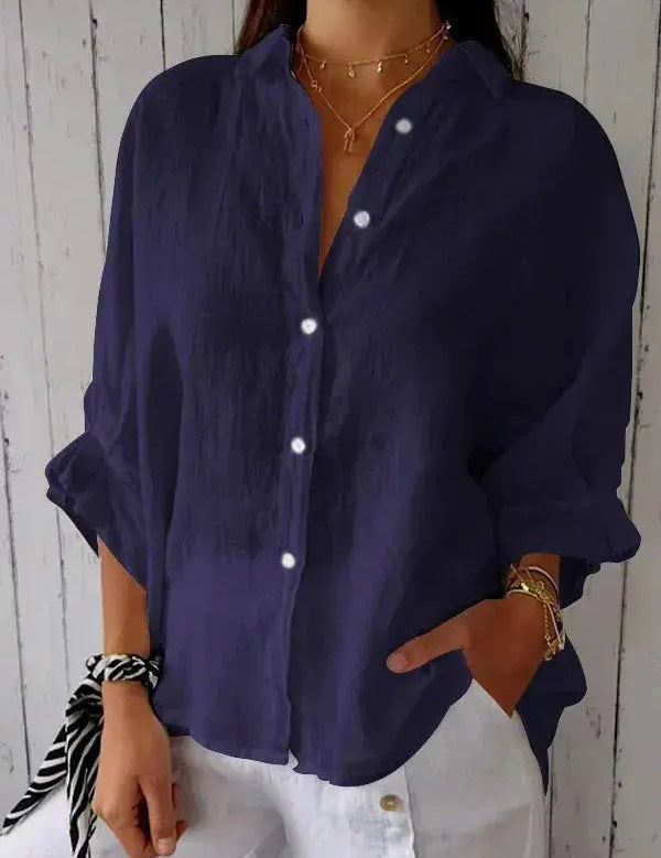 Camicia donna blu scuro in lino, maniche lunghe, bottoni bianchi, abbinata a pantaloni bianchi. Stile casual elegante, moda estiva.