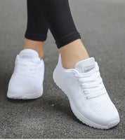 Scarpe da corsa bianche da donna su strada asfaltata, design traspirante, suola antiscivolo, ideali per jogging e attività sportive all'aperto.