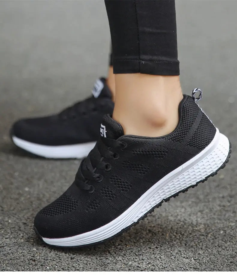 Scarpe da ginnastica nere da donna, suola bianca antiscivolo, design traspirante, ideali per corsa e sport. Comfort e stile casual.