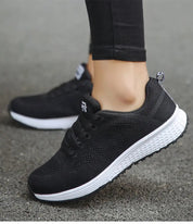 Scarpe da ginnastica nere da donna, suola bianca antiscivolo, design traspirante, ideali per corsa e sport. Comfort e stile casual.