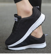 Scarpe da ginnastica nere unisex, suola bianca antiscivolo, design traspirante, ideali per corsa e sport. Comfort e stile casual.