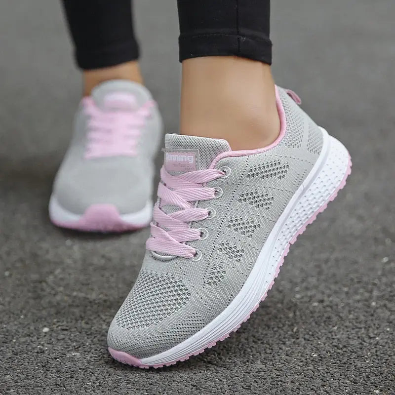 Scarpe da corsa donna grigie con lacci rosa, suola antiscivolo, design traspirante, ideali per sport e fitness.