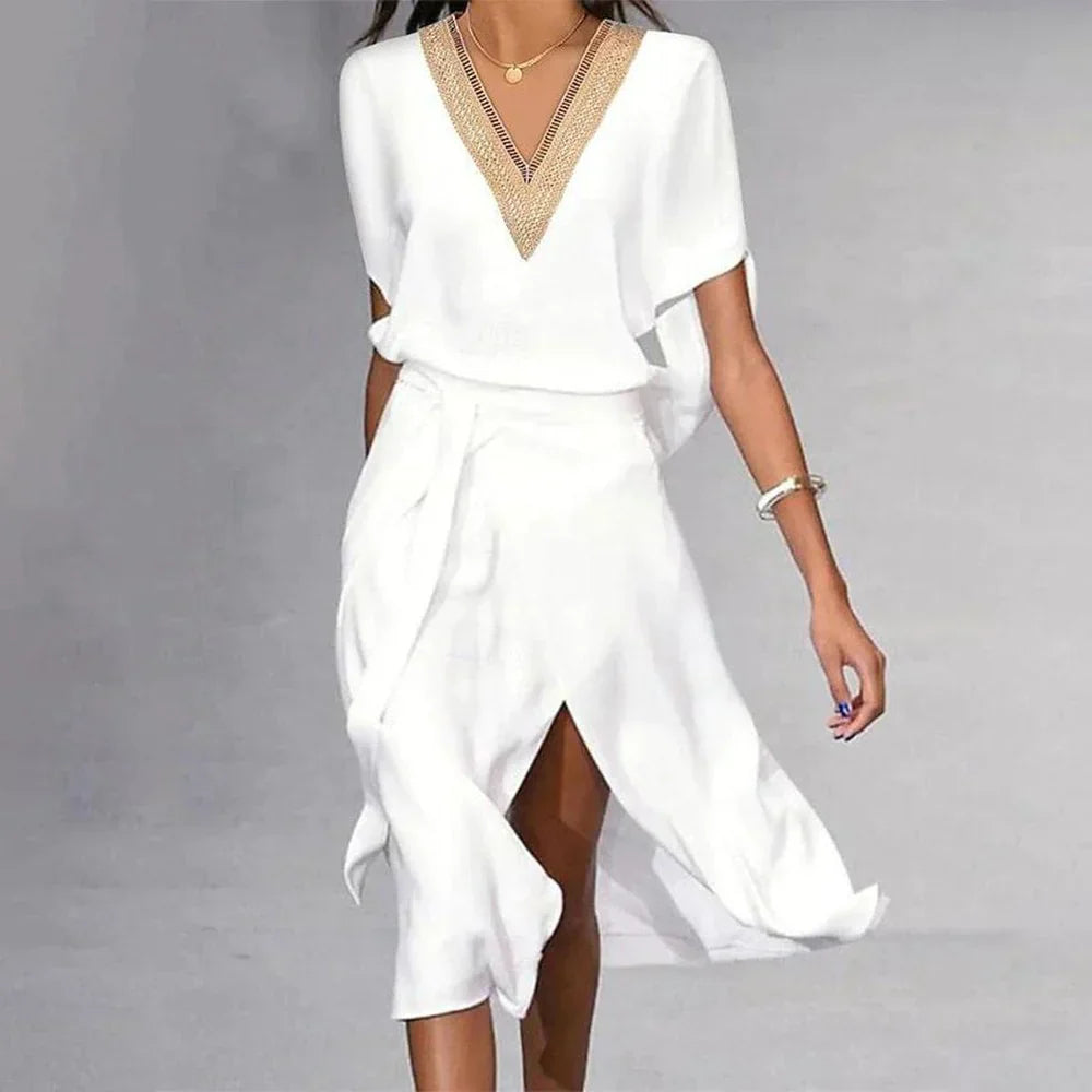Abito bianco elegante con scollo a V decorato, maniche corte, gonna a portafoglio. Perfetto per eventi estivi e cerimonie. Moda donna chic.