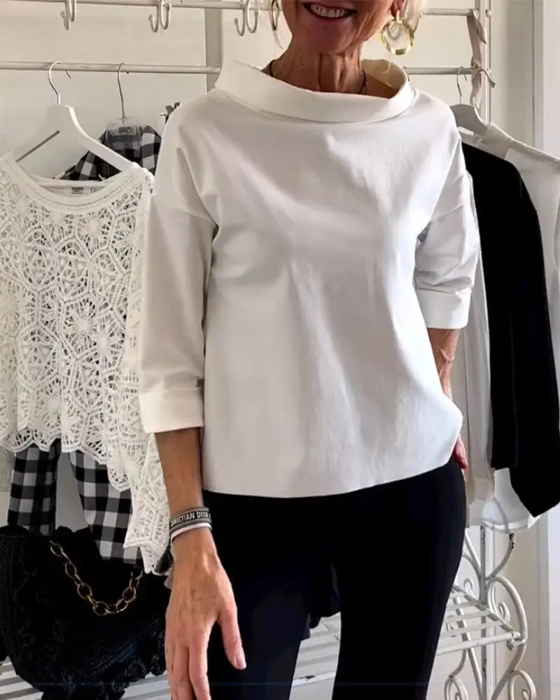 Donna indossa maglia bianca a maniche lunghe, con abbigliamento casual sullo sfondo. Moda femminile, stile elegante, abbigliamento quotidiano.