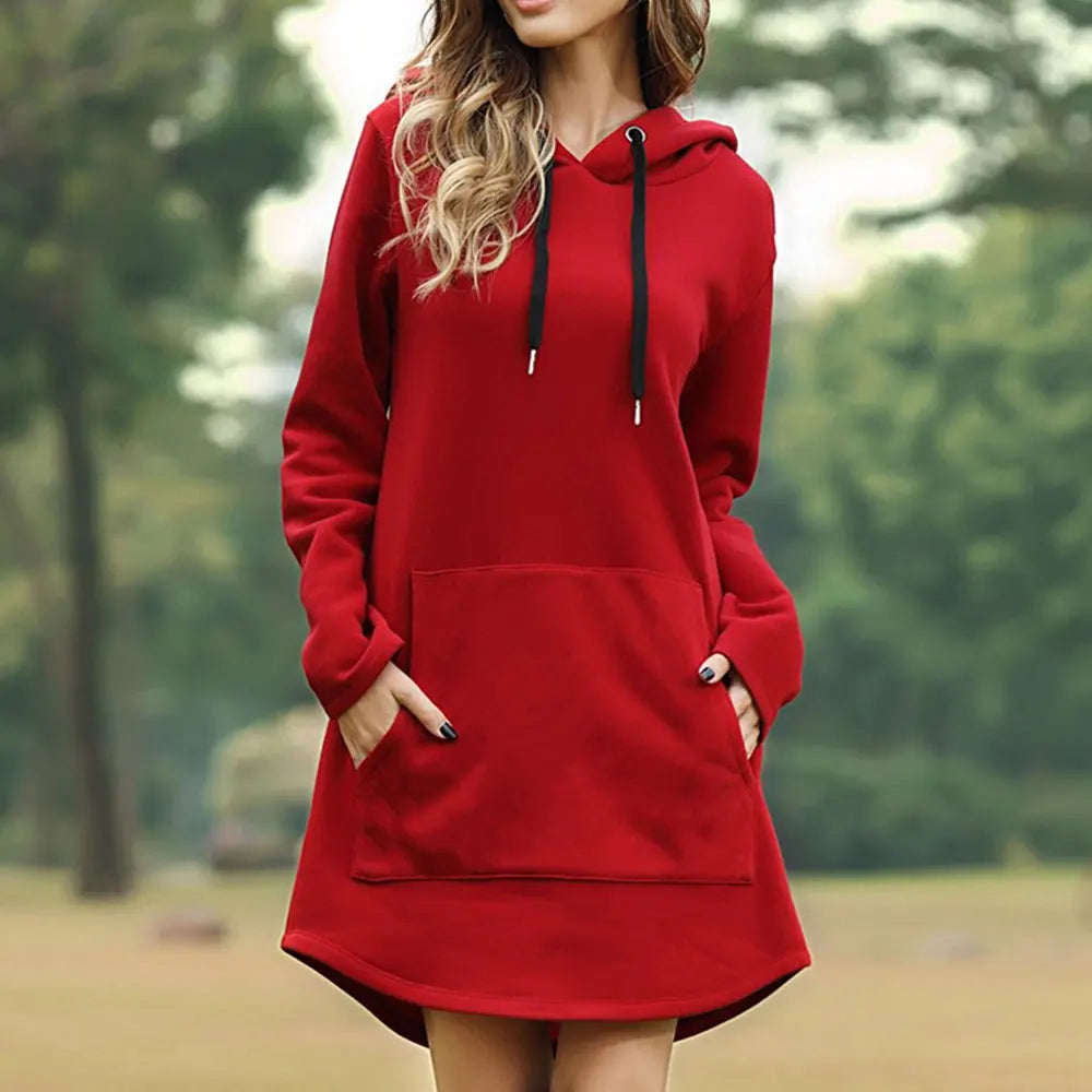 Donna con felpa rossa con cappuccio, tasca frontale e lacci neri, in un parco. Abbigliamento casual autunnale, moda donna, stile confortevole.