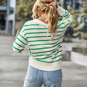 Maglione a righe verdi e bianche, donna di spalle, jeans chiari, strada urbana. Moda casual autunnale, look trendy, abbigliamento femminile.