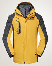 Giacca impermeabile da uomo gialla e grigia con cappuccio, antivento, ideale per escursioni e attività outdoor. Design moderno e funzionale.