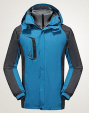Giacca impermeabile da uomo blu e grigia con cappuccio, tasca con zip, ideale per escursioni e attività outdoor. Design sportivo e resistente.