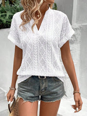 Donna con camicetta bianca traforata e shorts di jeans, look estivo casual. Moda femminile, abbigliamento leggero, outfit trendy per giornate calde.