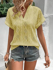 Donna con camicetta gialla traforata e shorts di jeans, look estivo casual. Moda femminile, abbigliamento leggero, tendenze estive 2023.