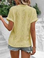 Donna con maglia gialla a maniche corte in maglia traforata, abbinata a shorts di jeans. Look estivo casual, moda femminile trendy.