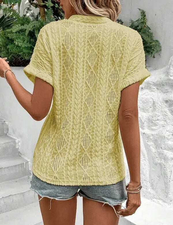 Donna con maglia gialla a maniche corte in maglia traforata, abbinata a shorts di jeans. Look estivo casual, moda femminile trendy.