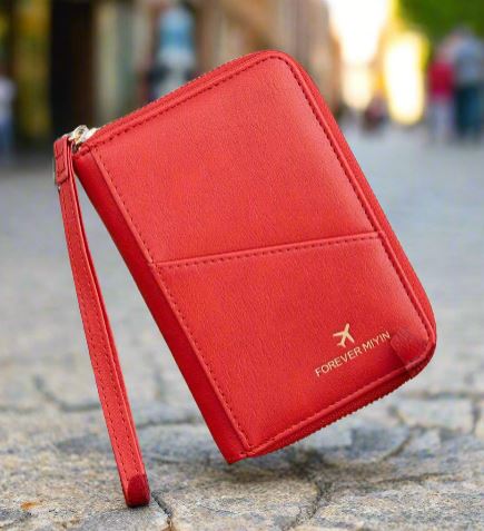 Portafoglio rosso in pelle con cerniera, design elegante, marchio "Forever My Way", su sfondo urbano sfocato. Accessorio moda donna.