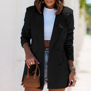 Donna con blazer nero elegante, top bianco e shorts di jeans, tiene una borsa marrone. Moda casual chic, abbigliamento femminile trendy.