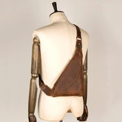 Zaino monospalla in pelle marrone su manichino, design ergonomico, stile vintage, ideale per uomo, accessorio moda, alta qualità artigianale.