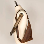 Borsa a tracolla in pelle marrone su manichino, design elegante e pratico, ideale per uomo, accessorio moda, stile vintage, alta qualità artigianale.