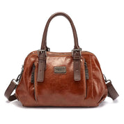 Borsa a mano in pelle marrone, design elegante con doppio manico, cerniere frontali e tracolla regolabile. Accessorio moda donna di tendenza.