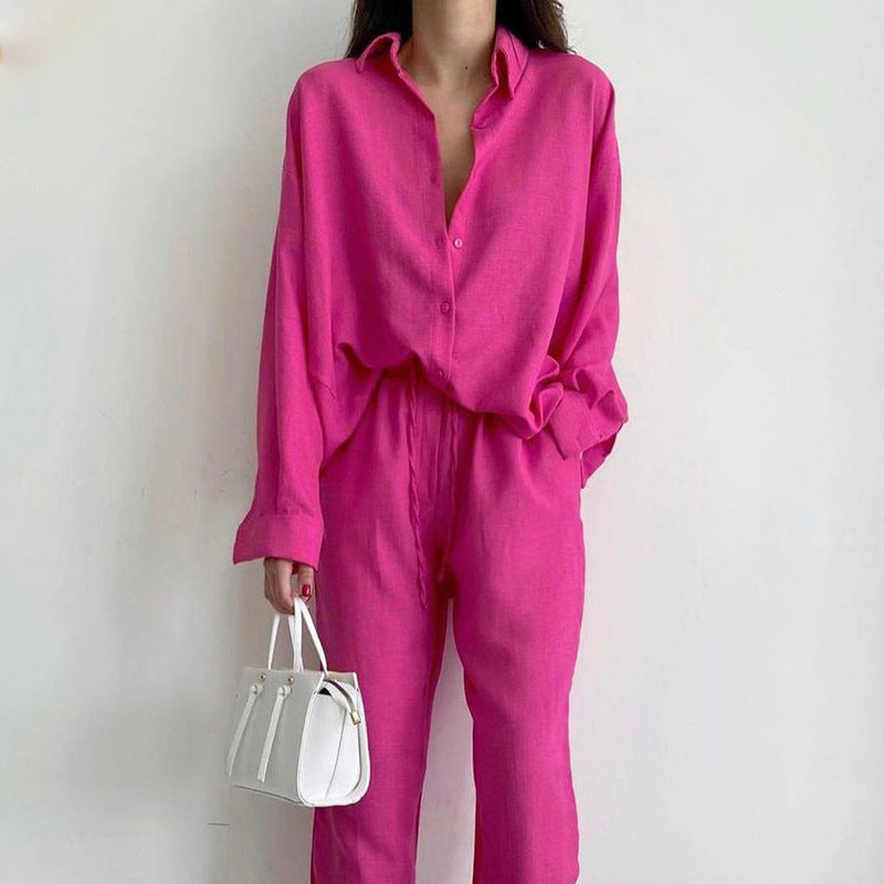 Donna con camicia e pantaloni fucsia, borsa bianca a mano. Moda femminile elegante, abbigliamento casual chic, tendenze colore vivace.