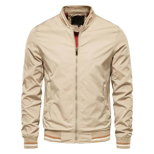 Giacca bomber beige da uomo, chiusura zip, colletto rialzato, polsini e orlo elasticizzati. Stile casual, moda autunno, tessuto leggero.