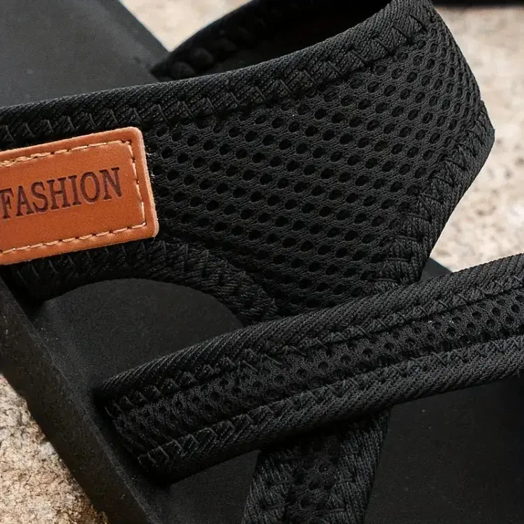 Sandali neri in tessuto traspirante con etichetta marrone "FASHION", suola in gomma, design casual estivo, perfetti per passeggiate all'aperto.