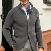 Giacca cardigan uomo grigia in maglia, abbinata a camicia bianca e foulard blu, stile casual elegante, moda autunno inverno.